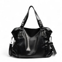 Grand sac hobo en cuir végan grainé noir, de face, anses rivetées et bandoulière détachable