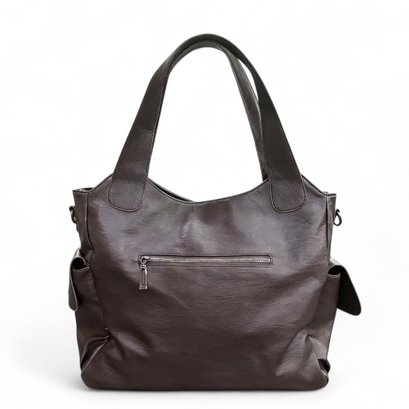 Arrière du sac brun café, zip horizontal centré, base élargie et sangle d'épaule laissée sur le côté