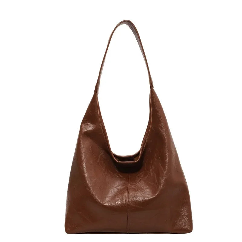 Cuir végan brun chocolat pour ce hobo à anse plate, base large et flancs souples, vu de face