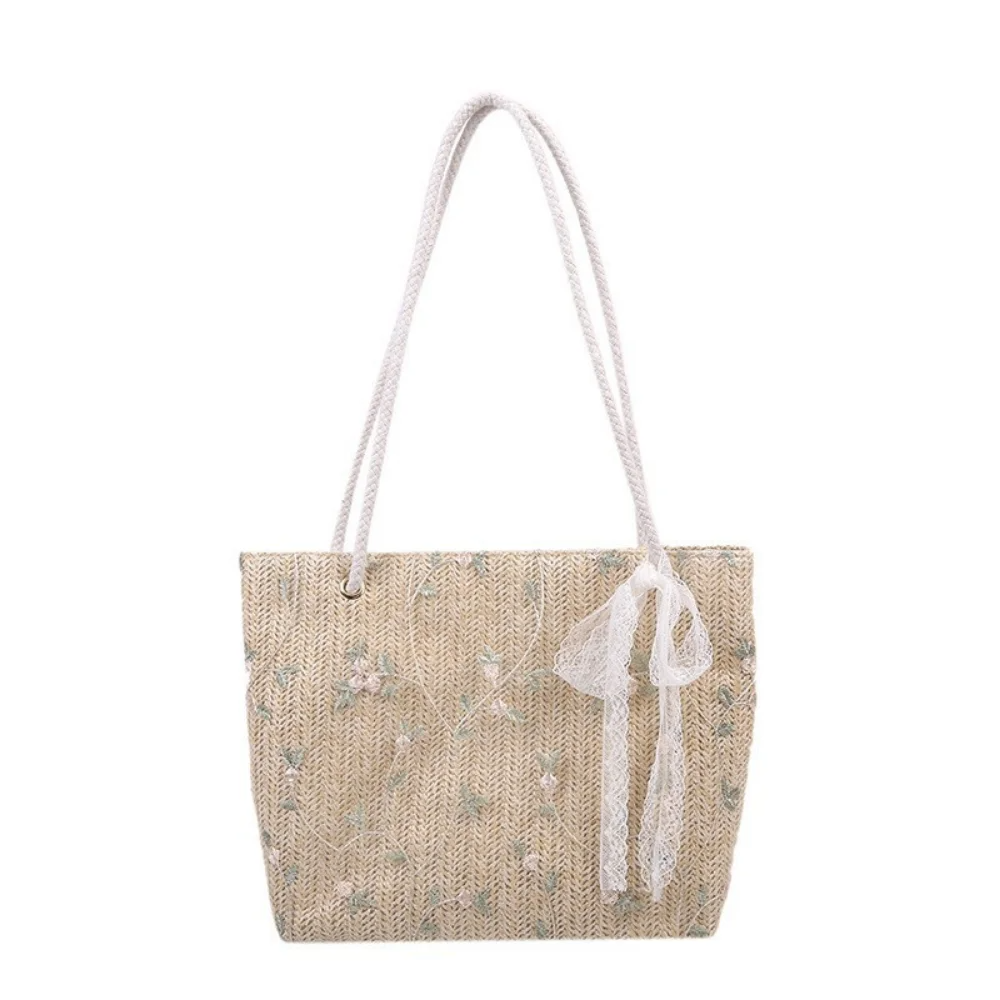 Paille naturelle beige et petites fleurs brodées, cabas de face, ruban de dentelle noué à l'anse