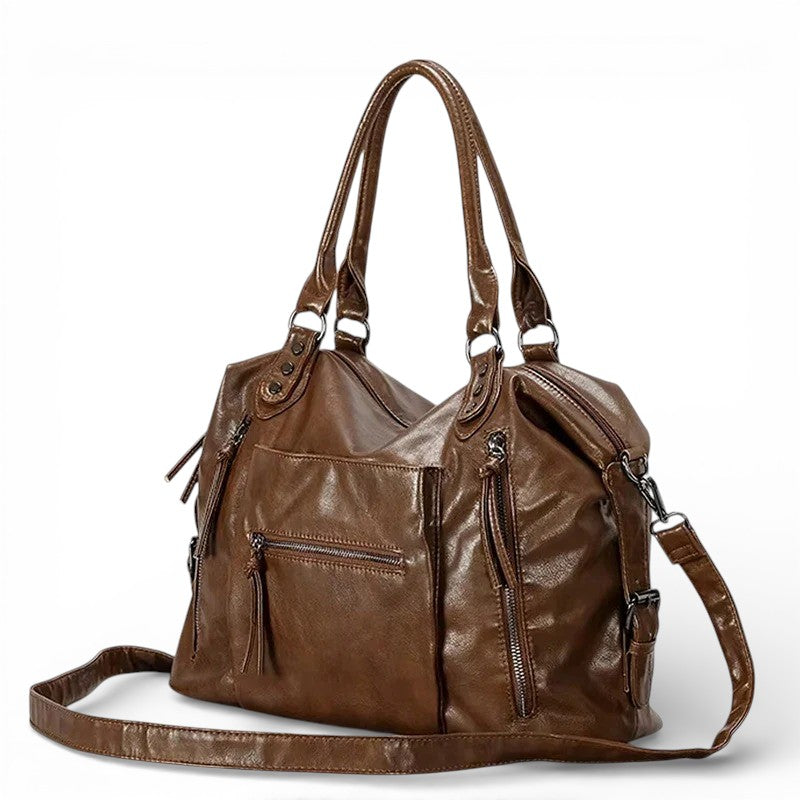 Trois quarts du sac marron, bandoulière amovible détachée et posée devant, zips à tirette