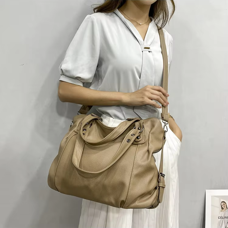 Fourre-tout beige grainé porté en croisé sur un chemisier blanc, bandoulière réglable en travers