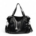 Grand sac hobo en cuir végan grainé noir, de face, anses rivetées et bandoulière détachable