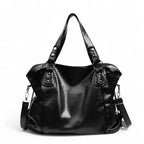 Grand sac hobo en cuir végan grainé noir, de face, anses rivetées et bandoulière détachable