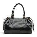 Sac bowling noir en cuir végan lustré, vue de face, anses courtes et boucles dorées