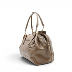 Profil trois quarts du sac taupe, base élargie, poche zippée verticale et anses souples