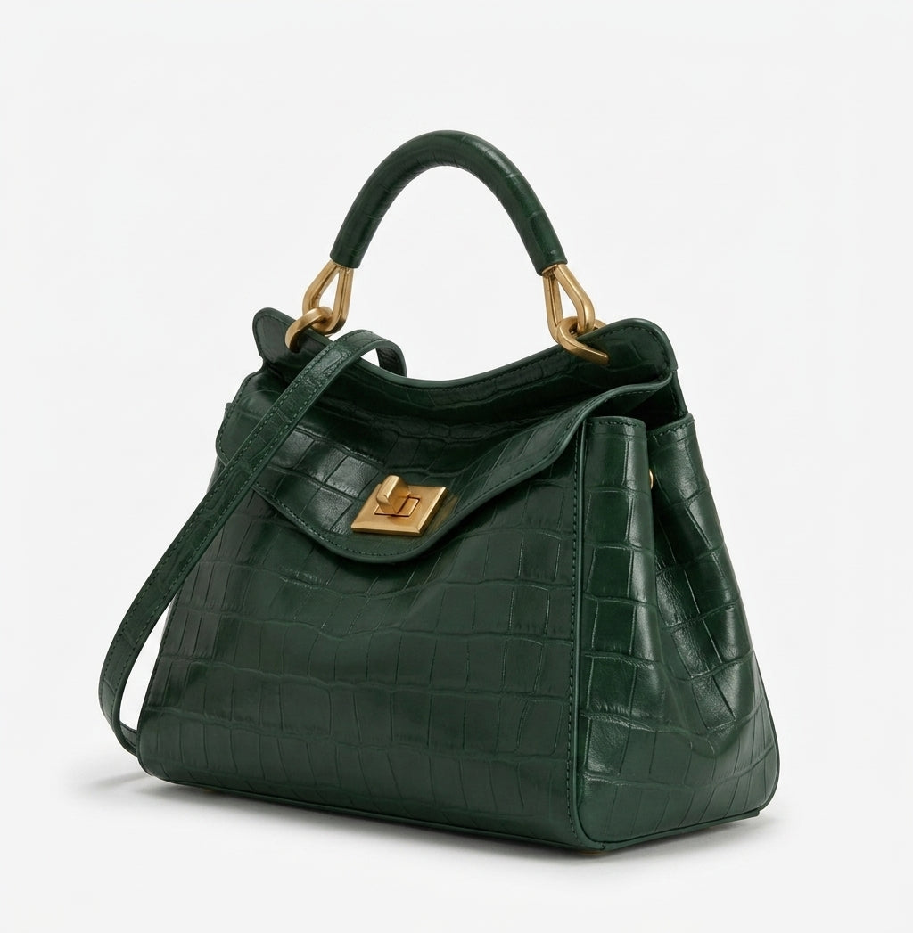 De trois quarts, sac vert sapin façon croco, soufflets latéraux souples et fermoir tourniquet doré