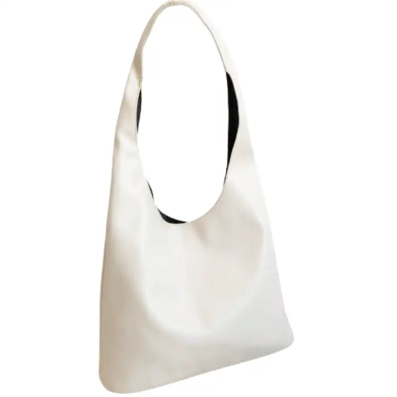 Blanc cassé légèrement ivoire, ce sac triangle souple se porte à l'épaule par une anse large