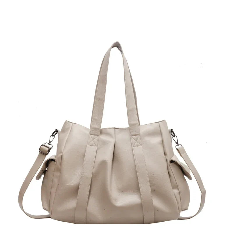 Version beige écru du même fourre-tout, anses larges, poches de côté et sangle réglable