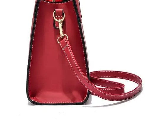 Détail de la bandoulière rouge réglable et de son mousqueton doré fixé sur le flanc du cabas