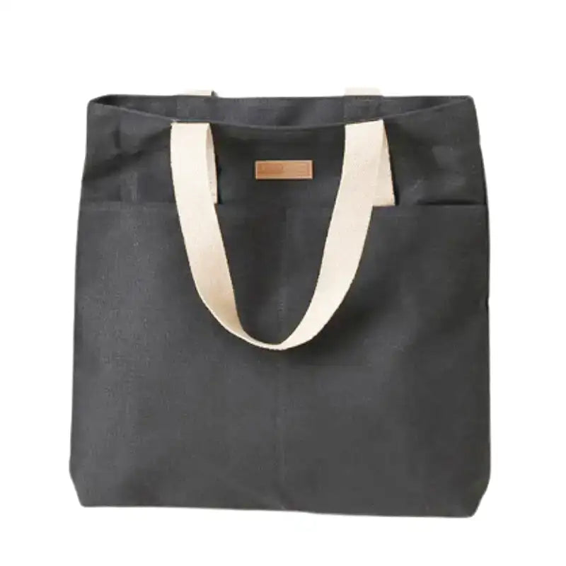Fourre-tout en toile gris anthracite à anses écrues, poche plaquée et petite étiquette, vu de face