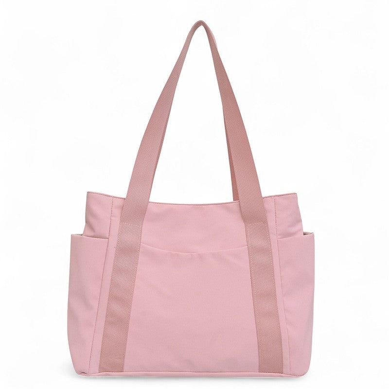 Nylon rose pâle pour ce cabas de trois quarts, anses hautes et poche frontale contrastée