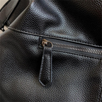 Détail du cuir végan grainé noir et de la poche zippée extérieure à tirette gainée de cuir
