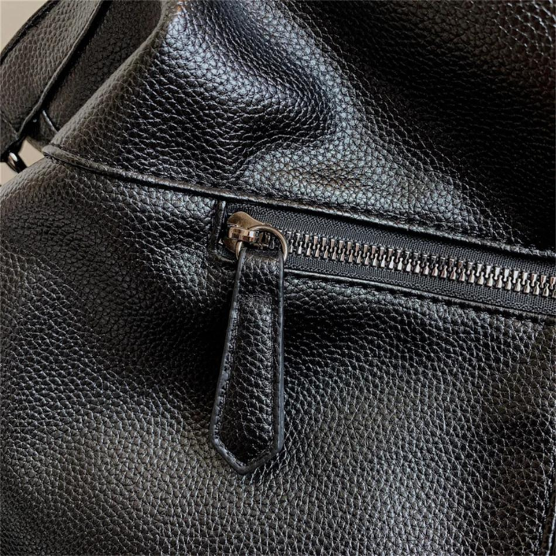Détail du cuir végan grainé noir et de la poche zippée extérieure à tirette gainée de cuir