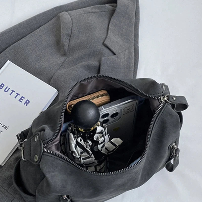 Ouvert par le haut, l'intérieur gris révèle parapluie, portefeuille et téléphone rangés côte à côte