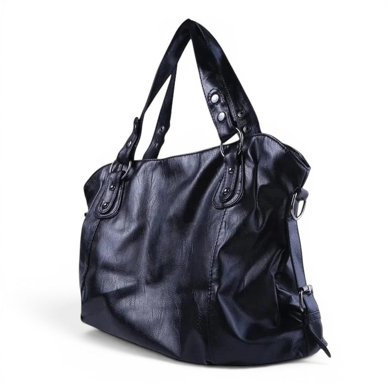 Bleu marine profond pour ce hobo vu de trois quarts, plis souples du cuir végan et anneaux métal