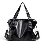 Sac hobo noir en cuir végan lustré, de face, anses rivetées et bandoulière amovible à mousquetons