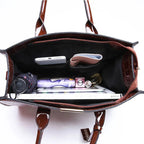 Intérieur doublé de noir, poche zippée et contenu du quotidien : téléphone, parapluie et carnets