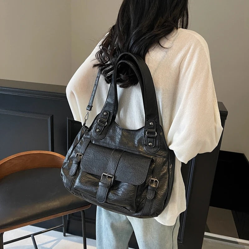 Porté à l'épaule de dos sur un pull écru, le hobo noir se cale contre la hanche, anse large