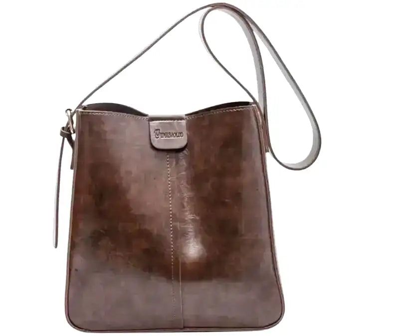 Simili patiné brun café sur un sac seau à bandoulière, présenté de face sur fond blanc