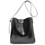 Cabas seau noir lustré à fine bandoulière, patte avant et petite pochette zippée sur le côté