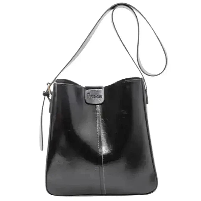 Cabas seau noir lustré à fine bandoulière, patte avant et petite pochette zippée sur le côté