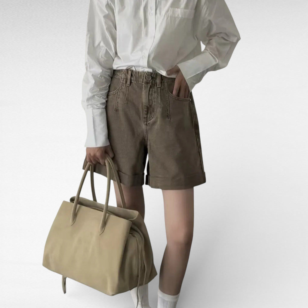 Mannequin en short marron portant le cabas beige taupe à la main, chemise blanche rentrée