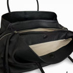 Intérieur du cabas noir ouvert, doublure écrue et large poche zippée sur toute la longueur