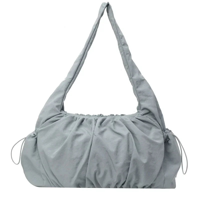 Bleu gris pâle, ce sac épaule froncé montre son volume arrondi et ses cordons de réglage