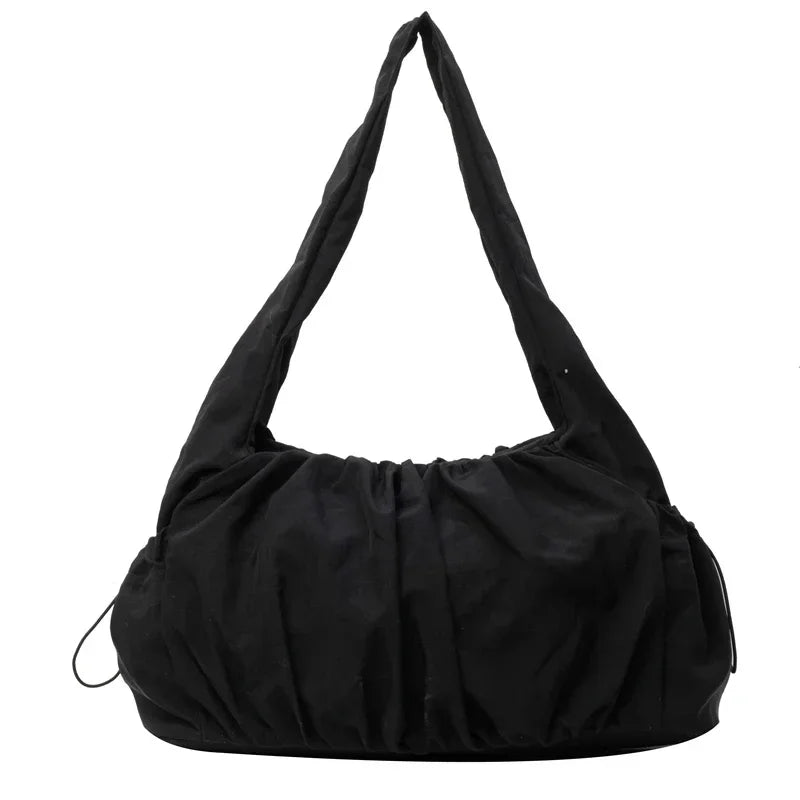 Hobo noir en nylon froissé, vu de face, sa longue anse formant un triangle au-dessus du corps