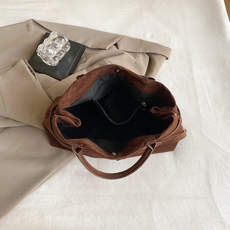 Intérieur du sac ouvert en vue plongeante, doublure noire unie et large ouverture sans cloison