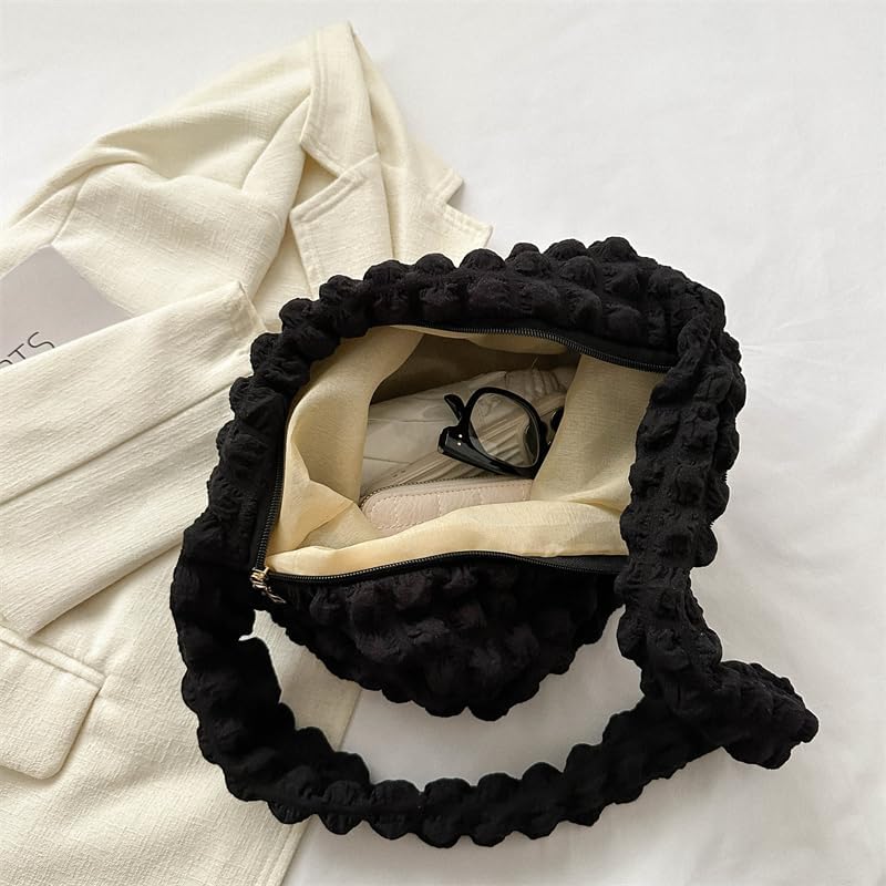 Doublure écrue et poche zippée à l'intérieur du sac noir ouvert, une paire de lunettes glissée dedans