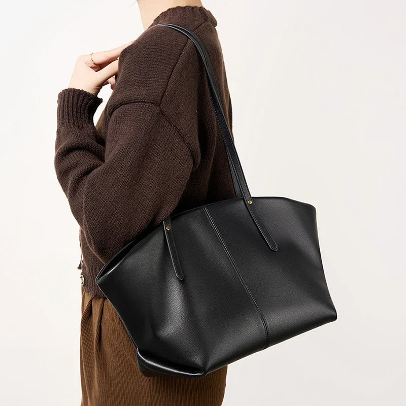 En appui sur l'épaule, avec un cardigan marron, le cabas noir tombe droit sans se déformer