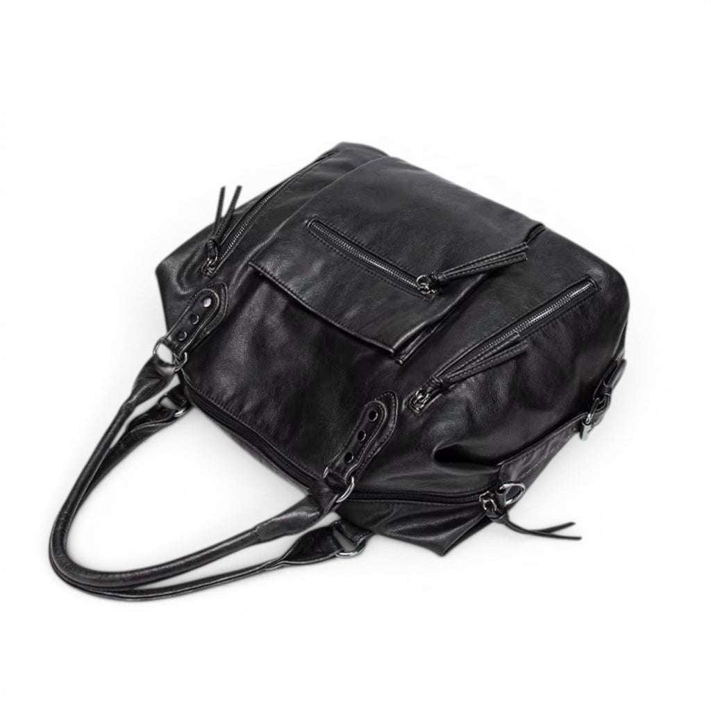 Face arrière du sac noir vue en plongée, poche zippée et anses rabattues sur le dessus