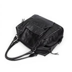 Face arrière du sac noir vue en plongée, poche zippée et anses rabattues sur le dessus