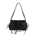 Sac baguette noir verni à poches plaquées et liens noués, vu de face, bandoulière courte tendue