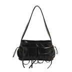 Sac baguette noir verni à poches plaquées et liens noués, vu de face, bandoulière courte tendue