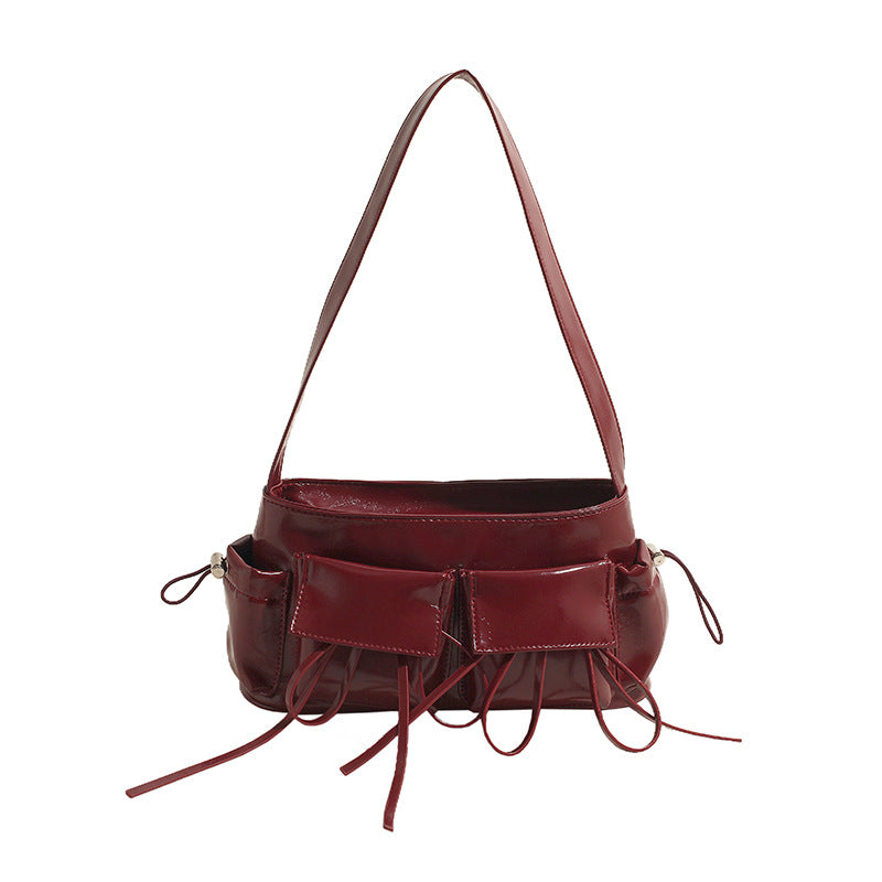 Cuir végan brillant rouge bordeaux, sac baguette souple de face, doubles poches et lacets pendants