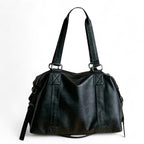 Sac polochon en cuir végan noir vu de face, doubles anses et bandoulière amovible à mousquetons