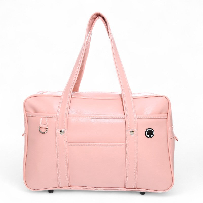 Rose poudré pour ce sac de cours rectangulaire, anses longues et passant rond sur le côté droit