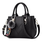 Petit sac à main noir structuré, pompon en fausse fourrure et bandoulière à inscription colorée