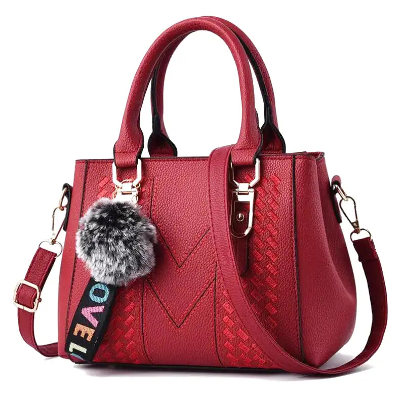 Rouge vif et lisse, sac à deux anses courtes, pompon de fourrure et sangle multicolore agrafée