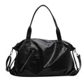 Grand sac polochon souple en cuir végan noir, anses courtes, bandoulière amovible et zip en biais