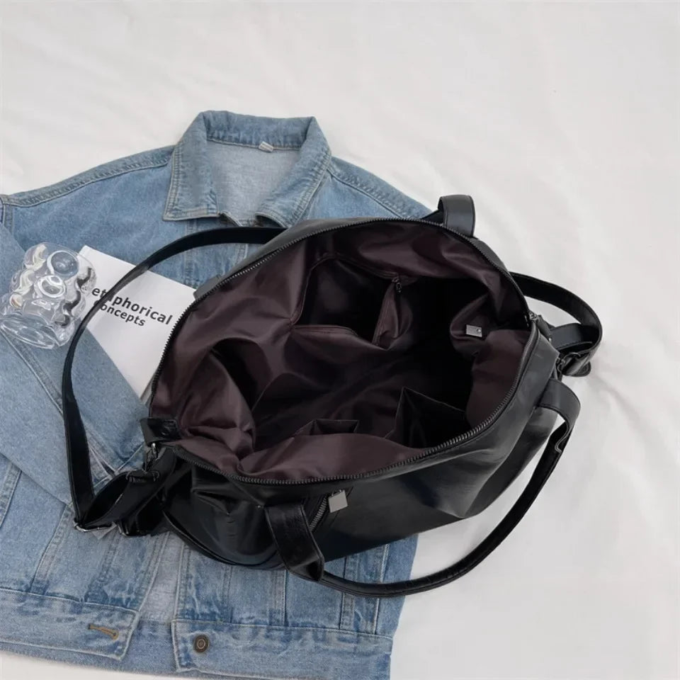 Intérieur doublé largement ouvert sur une veste en jean, poche plaquée et sangle bandoulière noire