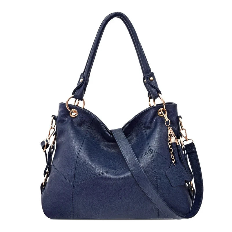 Bleu marine et coutures en chevron, ce hobo souple porte une longue bandoulière réglable