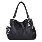 Sac hobo noir en cuir végan grainé, anses doubles, breloque à pompon et bandoulière amovible