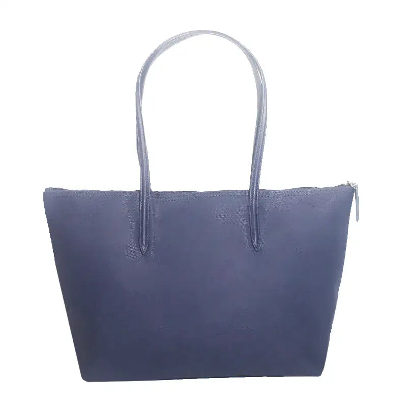 Bleu marine, ce grand sac zippé à anses longues montre une base élargie et des flancs souples