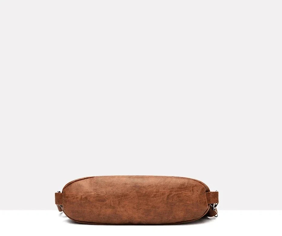 Dessous arrondi du hobo cognac, mousquetons latéraux et surpiqûres du fond parfaitement visibles