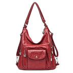 Hobo en cuir végan rouge profond, de face, anse d'épaule, poche à rabat et zips latéraux argentés