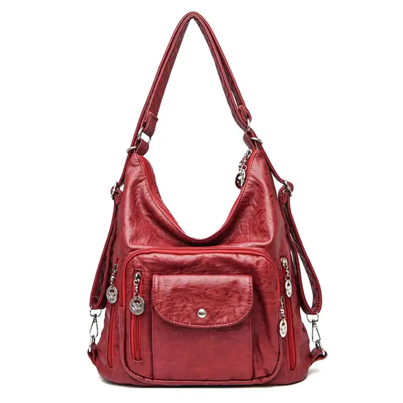 Hobo en cuir végan rouge profond, de face, anse d'épaule, poche à rabat et zips latéraux argentés